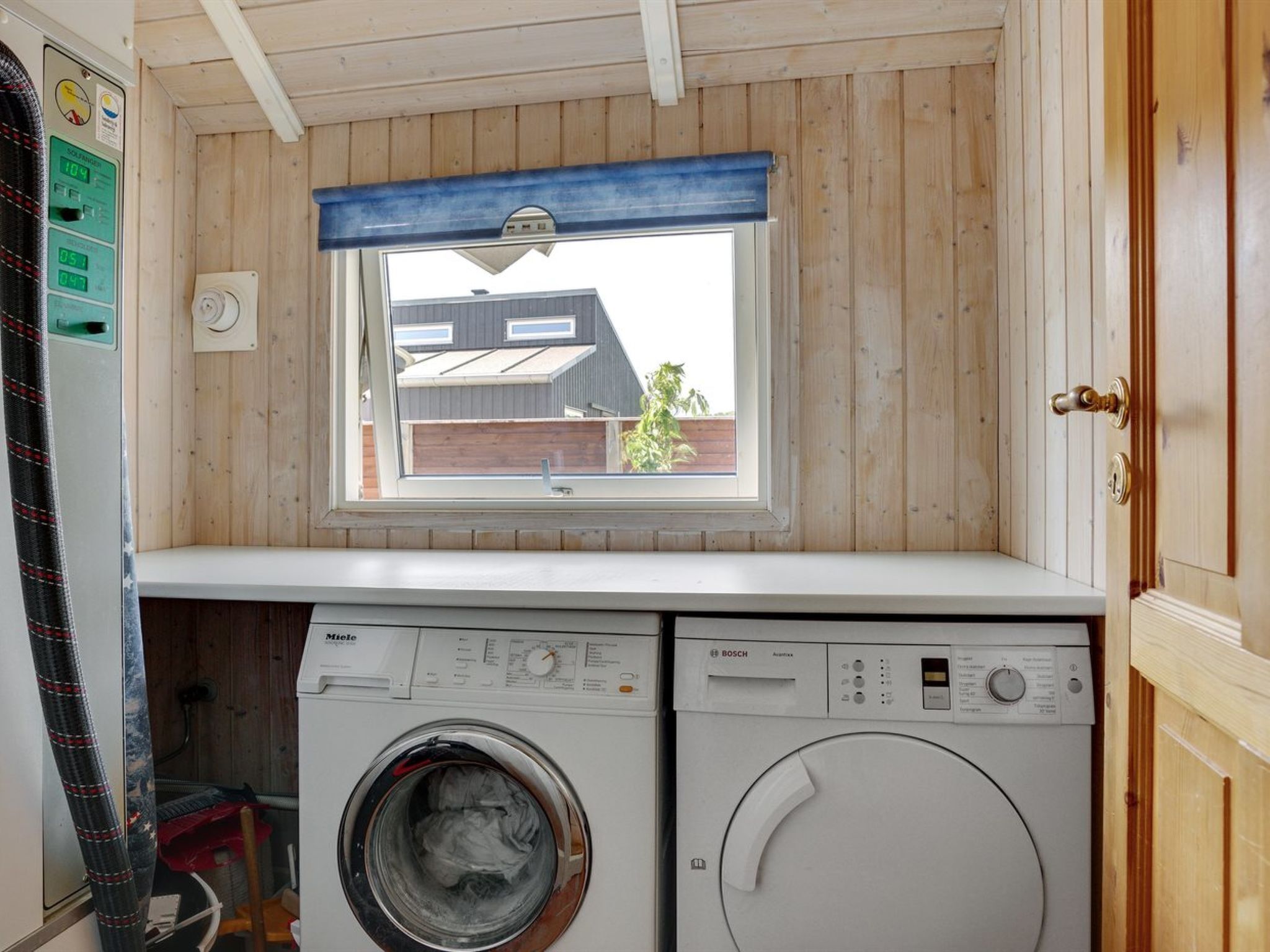 Une petite buanderie avec une fenêtre, un lave-linge et un sèche-linge.