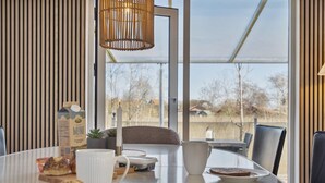 Un espace repas moderne avec une table ronde, une bougie, un carton de lait et des pâtisseries.