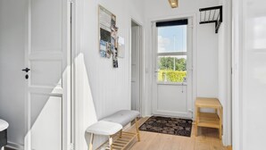 A hallway with a bench, a small table, and a door with a bulletin board. - "Fiete" - 200m from the sea by Interhome (Bjert)
