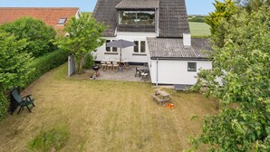A two-story house with a patio area, a barbecue grill, and a small table with chairs. - "Truels" - 2km from the sea by Interhome (Tranekær)