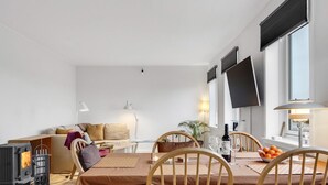 A modern living room with a dining area, a fireplace, and a TV mounted on the wall. - "Truels" - 2km from the sea by Interhome (Tranekær)