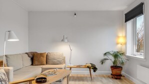 A modern living room with a sofa, a coffee table, a floor lamp, a side table, and a potted plant. - "Truels" - 2km from the sea by Interhome (Tranekær)