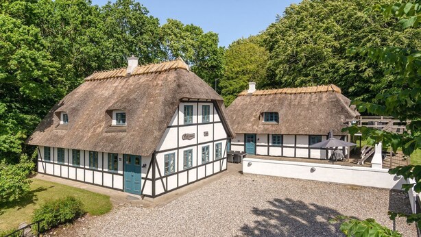 A traditional half-timbered house with a thatched roof, surrounded by a gravel driveway and lush greenery. - "Sirkku" - 320m from the sea by Interhome (Tranekær)