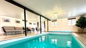 An indoor swimming pool with a tiled floor, surrounded by a sofa, chairs, and a potted plant. - "Sirkku" - 320m from the sea by Interhome (Tranekær)