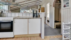 A modern kitchen with white cabinetry, a built-in oven, and a stainless steel range hood. - "Roel" - 500m from the sea by Interhome (Tranekær)