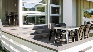 A modern outdoor patio with a deck, a table, and chairs. - "Roel" - 500m from the sea by Interhome (Tranekær)