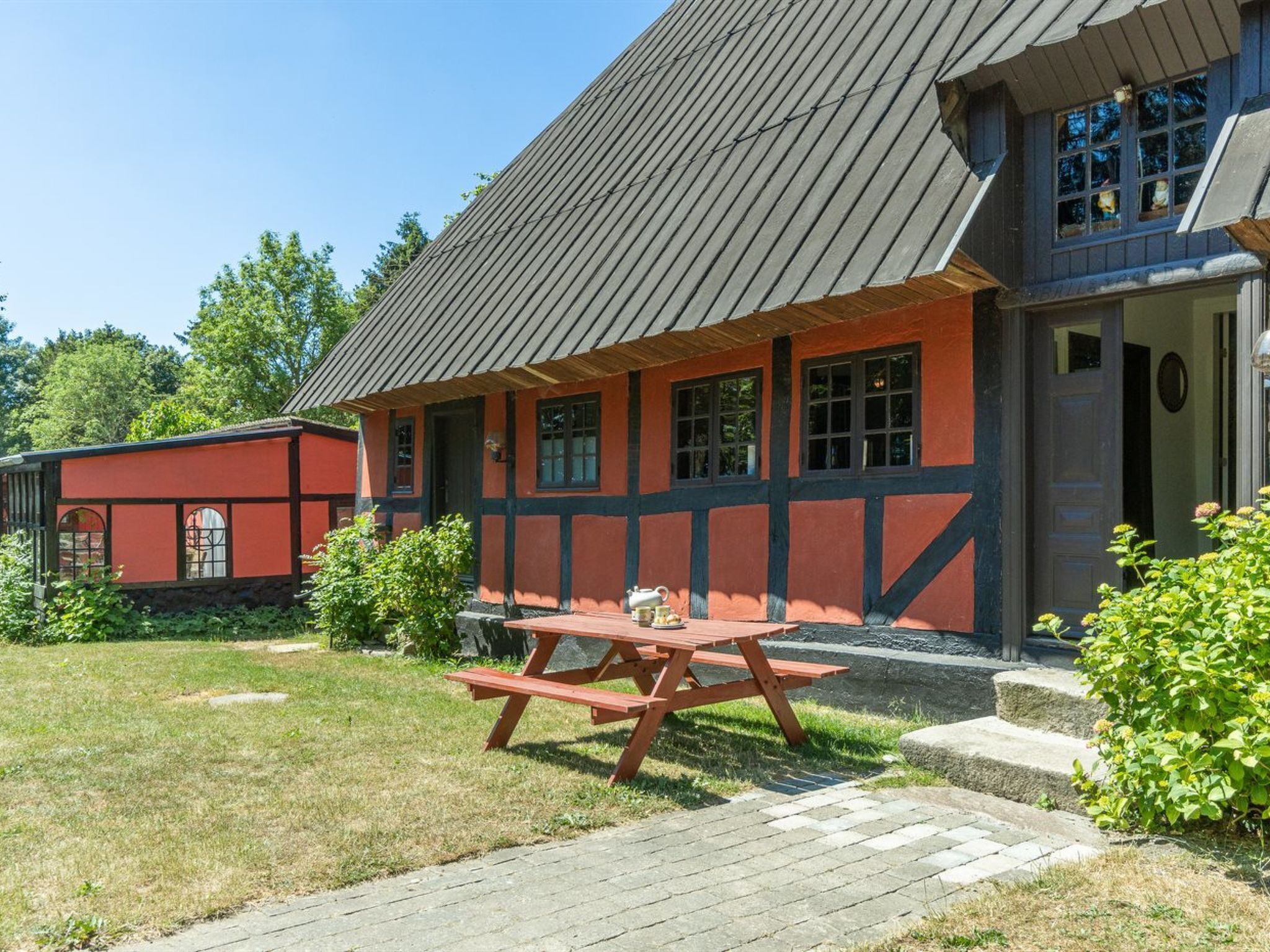 Un bâtiment traditionnel doté d’un toit en pente et d’une façade rouge et noire.