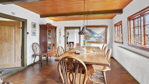 A dining area with a long wooden table, chairs, and a chandelier. - "Elvin" - 2.7km from the sea by Interhome (Humble)