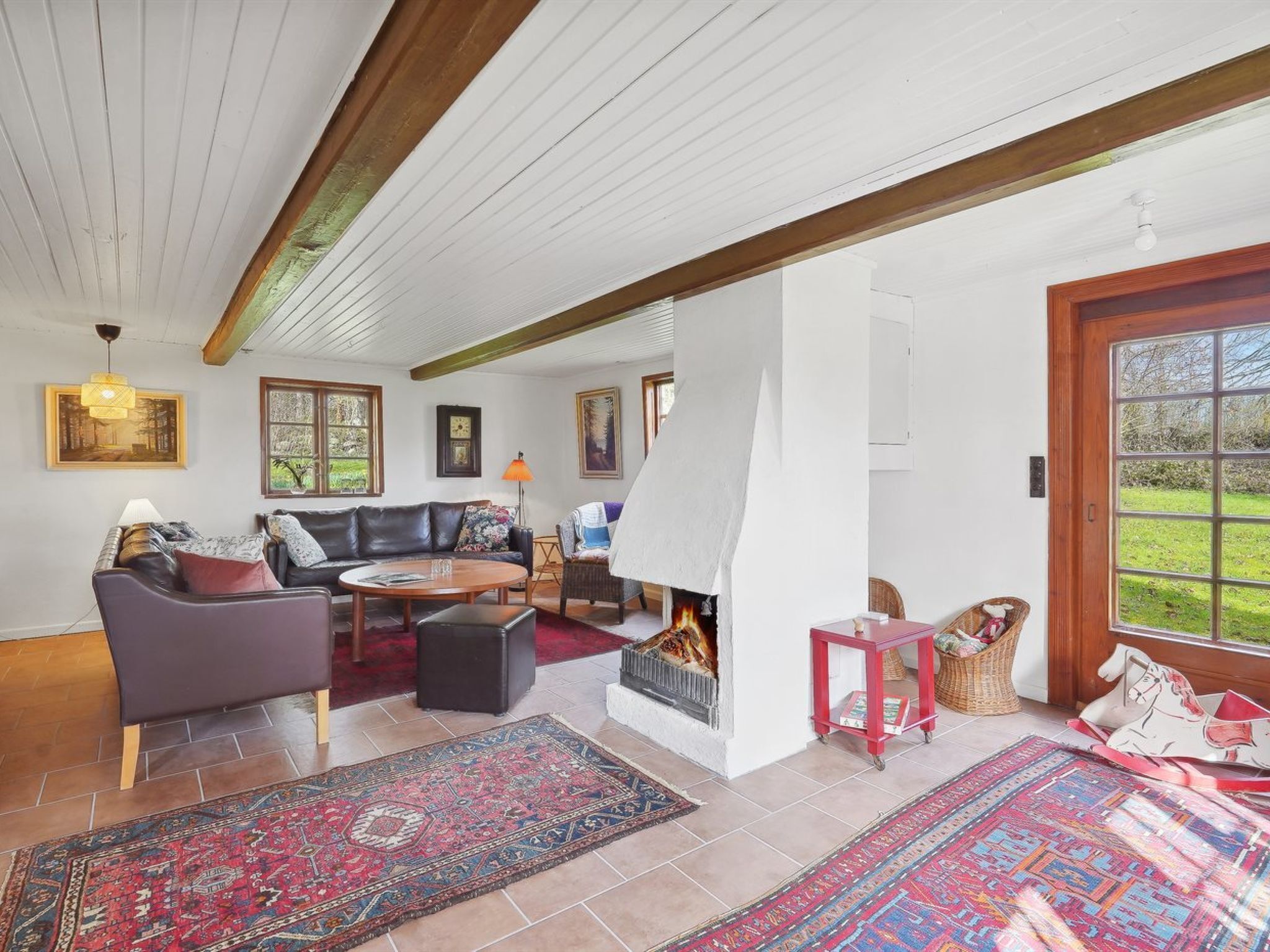 A cozy living room with a fireplace, a sofa, a coffee table, and a rug.