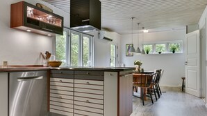 A modern kitchen with a built-in dishwasher, wooden cabinets, and a central island.