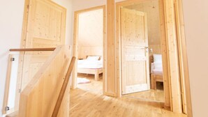 A wooden interior with a staircase, a bed, and a bathroom.