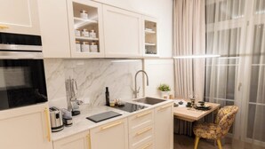 Eine moderne Küche mit Einbauofen, Spüle und Essbereich mit Tisch und Stuhl.