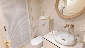 Ein Badezimmer mit Toilette, Waschbecken, Spiegel und Handtuchhalter.