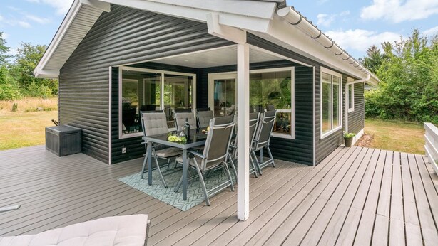 Un espace extérieur aménagé, abrité et doté d’une table et de chaises, d’une terrasse et d’une vue sur le paysage environnant.