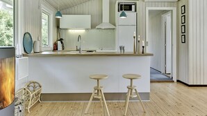 Une cuisine moderne dotée d’un îlot central, de meubles blancs et d’un plancher en bois.