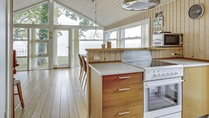 A kitchen with wooden cabinets, a stove, and a microwave.