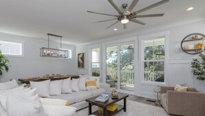A spacious living room with a large sofa, a coffee table, and a ceiling fan. - Luxury Hilton Head Marsh View Home | Pool & Kids' Loft (Hilton Head Island)