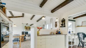A spacious kitchen with wooden beams, a central island, and a dining area with a table and chairs. - "Ylvie" - 150m from the sea by Interhome (Frørup)