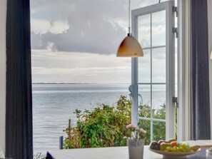 Una habitación con un ventanal que ofrece vistas a un cuerpo de agua y tierra distante.