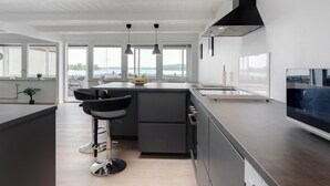 A modern kitchen with a central island, pendant lighting, and a view of the outdoors. - "Constance" - 50m from the sea by Interhome (Svendborg)