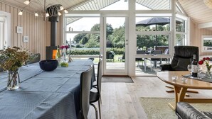 A spacious room with a large table and chairs, a fireplace, and a view of the outdoors. - "Rathi" - 250m from the sea by Interhome (Haarby)