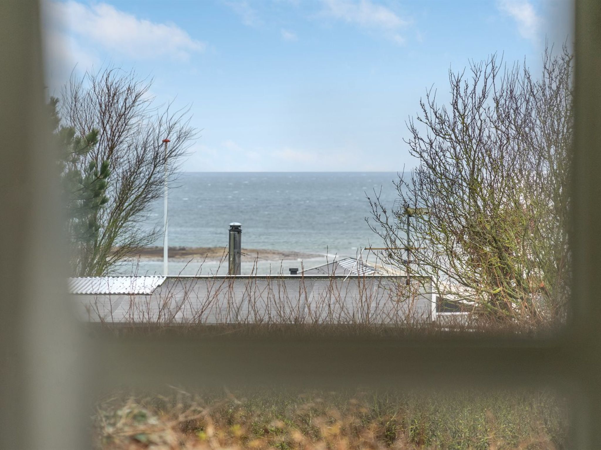Une vue sur la côte, avec une rambarde en métal, un lampadaire et une végétation clairsemée.