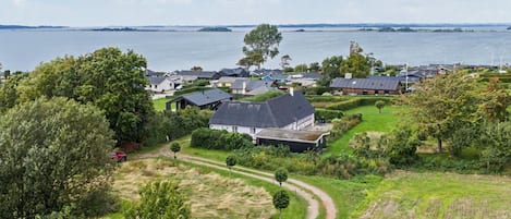 A residential area with houses, a body of water, and a clear sky.