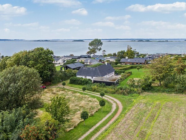 A residential area with houses, a body of water, and a clear sky.