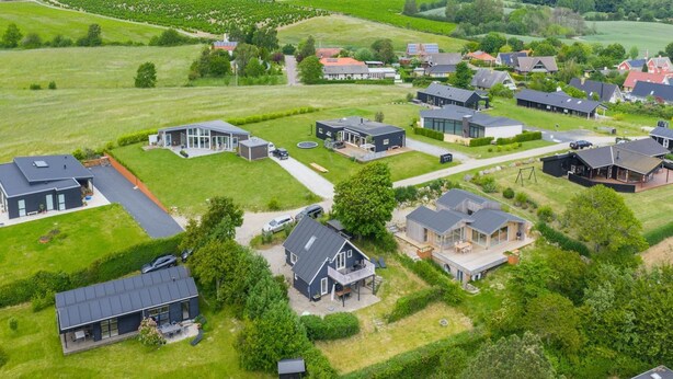 Un quartier résidentiel avec des maisons modernes, de vastes pelouses verdoyantes et un vignoble en arrière-plan.