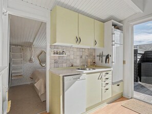 A compact kitchen with a sink, cabinets, and a dishwasher.