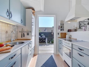 Enjoy cooking with a view in this kitchen featuring a sink, stove, and ample storage.