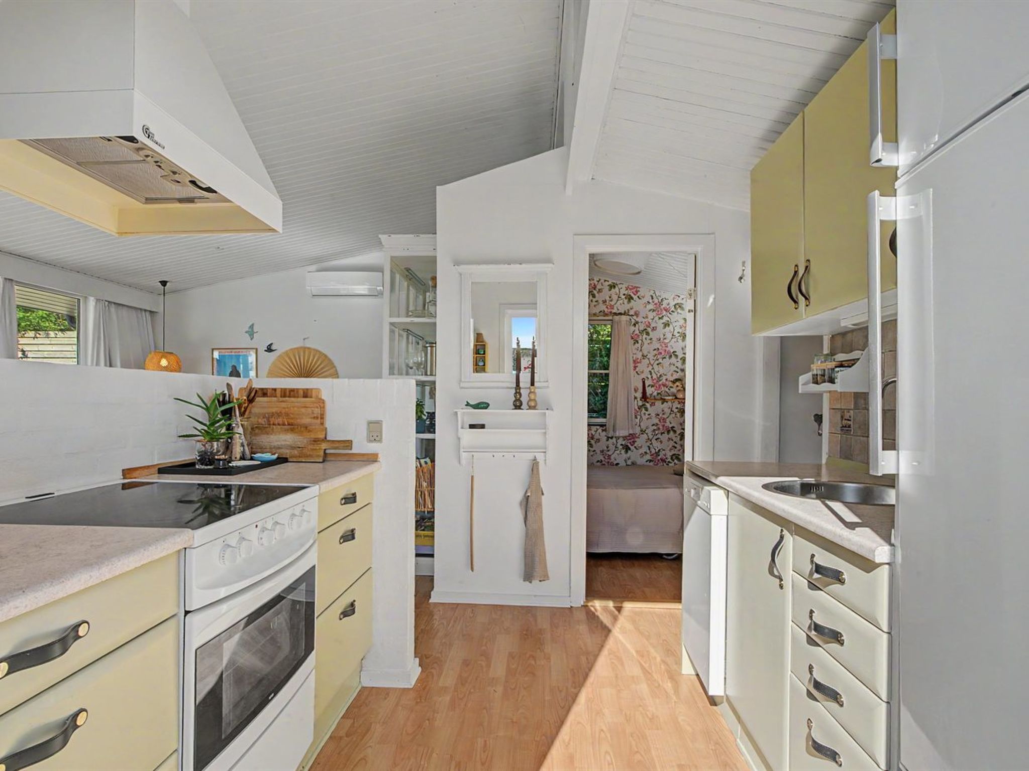 A modern kitchen with white cabinetry, a built-in oven, and a wooden countertop.