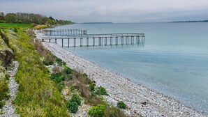 A pebbled beach with a wooden pier extending into calm waters. - "Annalia" - 50m from the sea by Interhome (Faaborg)