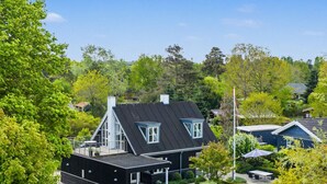 A modern house with a sloped roof, a covered patio, and a well-maintained garden. - "Gullan" - 75m from the sea by Interhome (Middelfart)