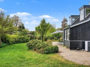 Una casa con jardín, un sendero y una zona de patio.