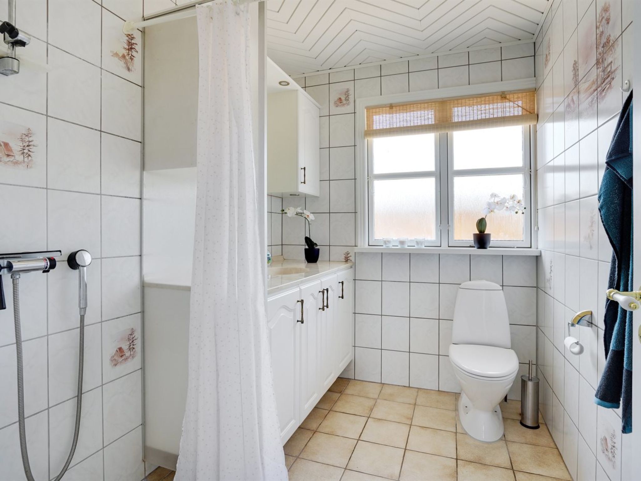 Een badkamer met douche, toilet en raam met uitzicht.