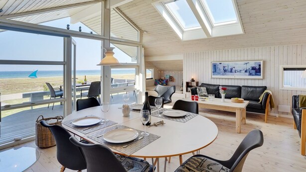 A spacious living area with a large round table, comfortable seating, and a view of the beach. - "Diertje" - 10m from the sea by Interhome (Otterup)