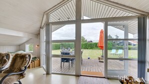 A spacious room with a large sliding glass door leading to an outdoor deck.