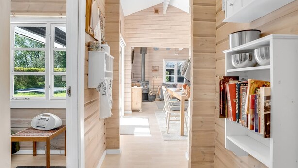Een gezellig cabin interieur met houten details, een eethoek en een boekenplank vol boeken.