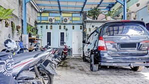 A covered parking area with a row of motorcycles and a Toyota SUV parked. - Hotel O Fajar Inn (Depok)