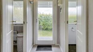 Un couloir étroit avec une porte donnant sur un jardin.