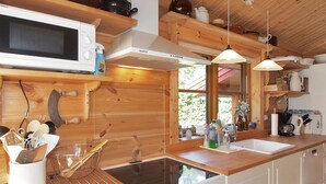 Eine moderne Küche mit Holzschränken, integriertem Mikrowellenherd, Herd und einem großen Fenster für natürliches Licht.