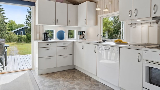 A modern kitchen with white cabinets, a Bosch oven, and a stone tile floor. - "Eini" - 500m from the sea by Interhome (Væggerløse)