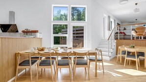 A modern kitchen with a dining area, wooden furniture, and a large window. - "Bjarka" - 700m from the sea by Interhome (Væggerløse)