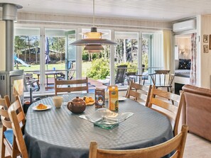 A dining area with a round table, chairs, a stove, and a view of the outdoors. - "Fenja" - 1.2km from the sea by Interhome (Væggerløse)