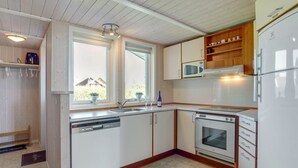A compact kitchen with white cabinets, a microwave, a dishwasher, and a stove.