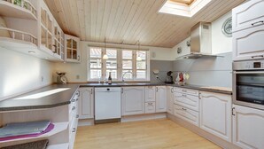 A modern kitchen with wooden cabinets, a Bosch oven, and a skylight. - "Sanna" - 330m from the sea by Interhome (Væggerløse)