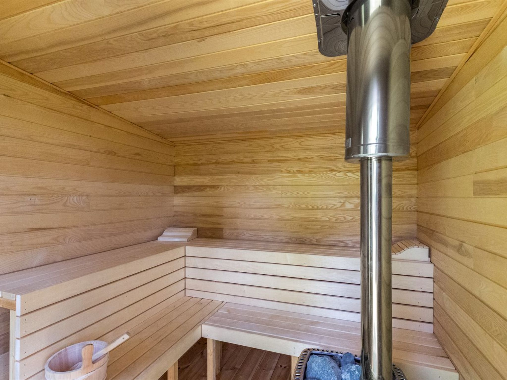 Una sauna con bancos de madera y un conducto de vapor central.