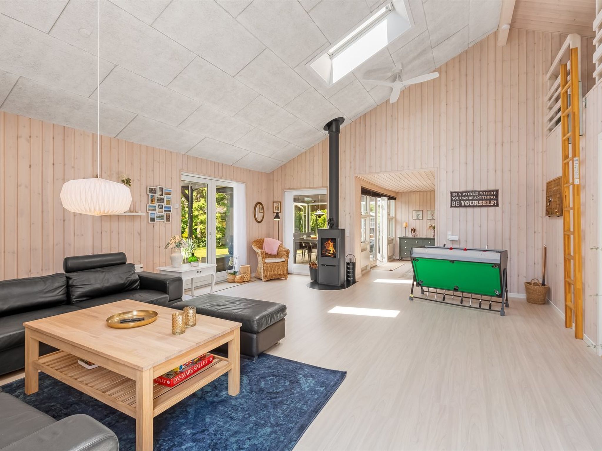 Un salon spacieux avec une cheminée, une table de billard et un coin salon confortable.