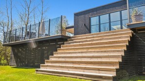 A modern building with a wooden staircase leading to a glass entrance. - "Engli" - 90m from the sea by Interhome (Væggerløse)